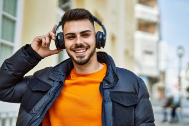 Yakışıklı, sakallı, neşeli ve kendine güvenen, kışlık palto giyen bir İspanyol.