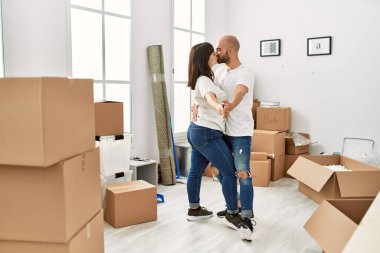 Genç İspanyol çift yeni evinde öpüşüyor ve dans ediyor..