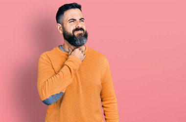 Sakallı, sıradan bir kazak giyen, boynuna dokunan soğuk algınlığı, boğaz ağrısı ve enfeksiyon geçiren İspanyol bir adam. 