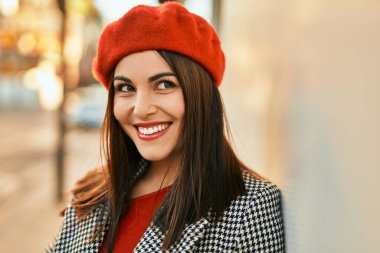 Genç İspanyol kadın gülümseyerek şehirde mutlu mesut dikiliyor..