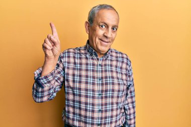 Yakışıklı, gri saçlı, sıradan tişörtlü, yüzünde kocaman bir gülümseme olan, eli ve parmağı kameraya bakan son sınıf öğrencisi.. 