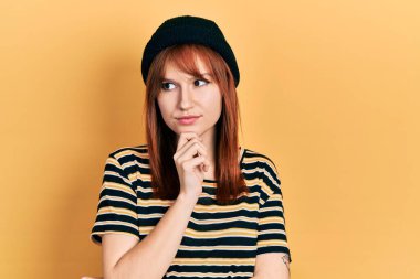 Kızıl saçlı, yün şapkalı, ciddi yüzlü, eli çeneli soru soran, kafa karıştırıcı fikirleri olan genç bir kadın. 