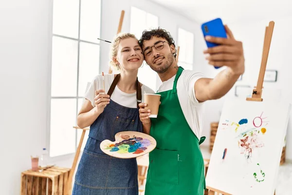 年轻的艺术家夫妇在艺术工作室用智能手机高兴地自拍 — 图库照片