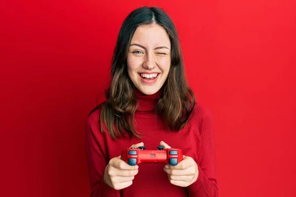 Young Brunette Woman Playing Video Game Holding Controller Winking Looking — Foto Stock