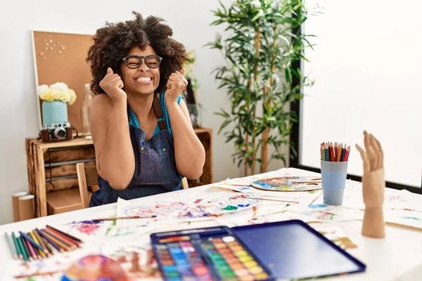 美丽的非洲裔美国女人 在艺术工作室里画着非洲的头发 兴奋地期待着成功 举起双臂 闭上双眼 微笑着庆祝胜利 获奖者概念 — 图库照片