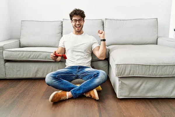 Hispanic Man Playing Video Game Holding Controller Sofa Screaming Proud — Stockfoto