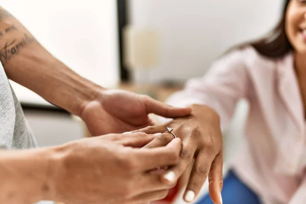 Hands of ouple on marriage proposal at the bedroom. Man putting engagement ring on woman finger.