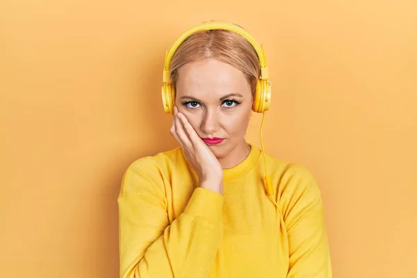 Młoda Blondynka Słuchająca Muzyki Pomocą Słuchawek Myśląca Wyglądająca Zmęczoną Znudzoną — Zdjęcie stockowe