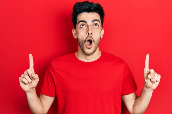 Young Hispanic Man Wearing Casual Clothes Amazed Surprised Looking Pointing — Stock Photo, Image