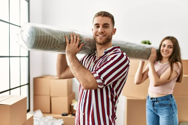 Pasangan Muda Kaukasia Tersenyum Bahagia Memegang Karpet Rumah Baru — Stok Foto