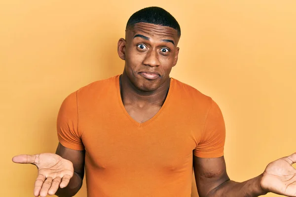 Joven Hombre Negro Con Camiseta Naranja Casual Expresión Despistada Confusa — Foto de Stock