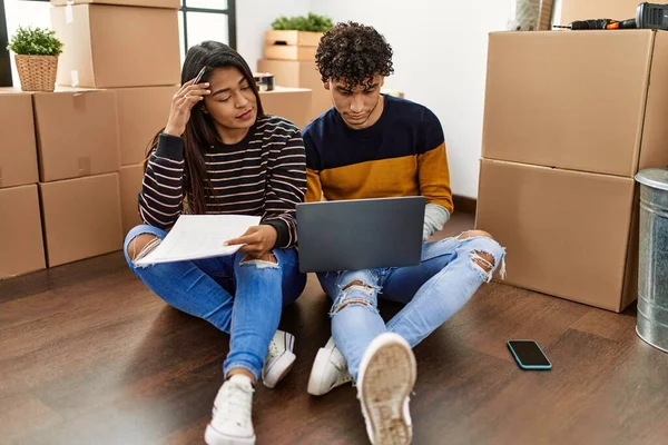 Young Latin Couple Serious Expression Using Laptop Sitting Floor New — Stockfoto