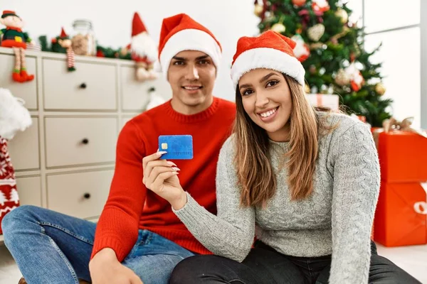 Casal Jovem Sorrindo Feliz Usando Chapéu Natal Sentado Chão Segurando — Fotografia de Stock