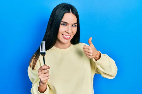 Young Brunette Woman Holding One Silver Fork Smiling Happy Positive — Stock Photo, Image