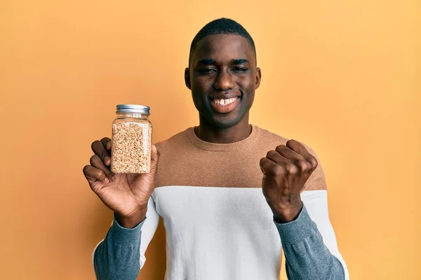 Young African American Man Holding Jar Rice Screaming Proud Celebrating — Stock Photo, Image