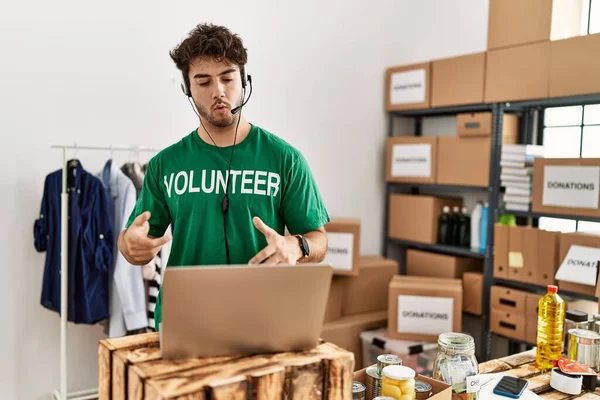 Joven Hispano Vistiendo Uniforme Voluntario Haciendo Videollamadas Centro Caridad —  Fotos de Stock