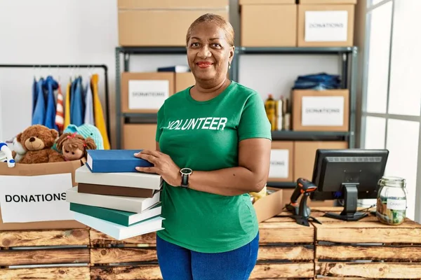 Senior African American Woman Wearing Volunteer Uniform Holding Books Charity — Stock Photo, Image