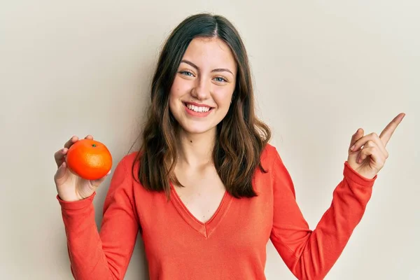 Junge Brünette Frau Mit Frischem Orange Lächelt Glücklich Und Zeigt — Stockfoto