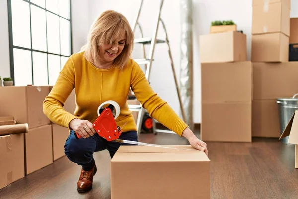 Middelbare Leeftijd Blonde Vrouw Verpakking Doos Met Behulp Van Tape — Stockfoto