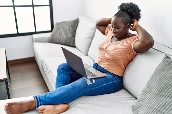 Młoda Afroamerykanka Zrelaksowana Dłońmi Głowie Pomocą Laptopa Domu — Zdjęcie stockowe