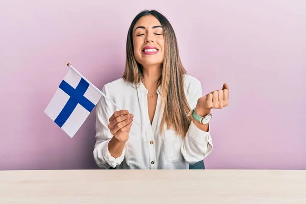 Junge Hispanische Frau Mit Finnischer Flagge Sitzt Auf Dem Tisch — Stockfoto