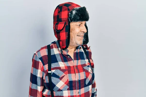 Jóképű Érett Férfi Téli Kalapban Fülvédővel Aki Oldalra Néz Mosollyal — Stock Fotó