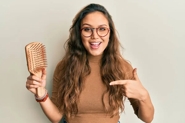 Joven Chica Hispana Sosteniendo Peine Pelo Señalando Con Dedo Uno —  Fotos de Stock