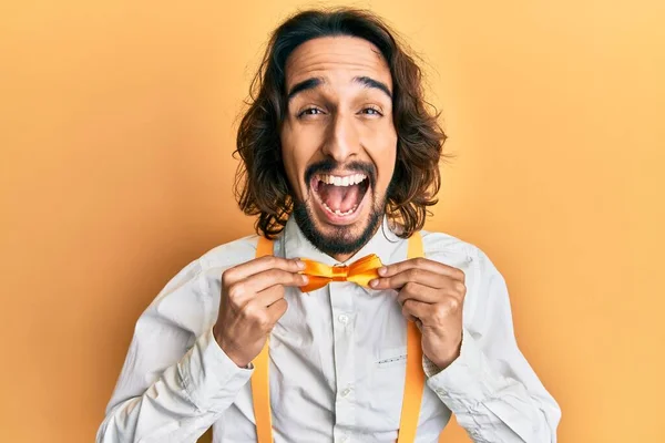 Νεαρός Ισπανόφωνος Άντρας Φορώντας Hipster Κομψό Βλέμμα Κρατώντας Παπιγιόν Χαμογελώντας — Φωτογραφία Αρχείου