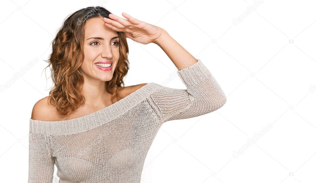 Beautiful young caucasian woman wearing casual clothes very happy and smiling looking far away with hand over head. searching concept. 