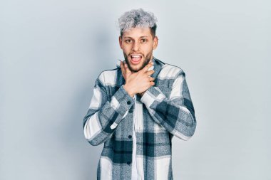 Modern boyalı saçlı, günlük gömlekli genç İspanyol adam bağırıyor ve boğuluyor çünkü acı verici bir boğulma. Sağlık problemi. Boğulma ve intihar konsepti. 