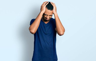 Genç Afro-Amerikalı bir adam gündelik tişört giyiyor. Baş ağrısı çekiyor, çaresiz ve stresli. Çünkü acı ve migren ağrısı var. Eller başının üstünde.. 