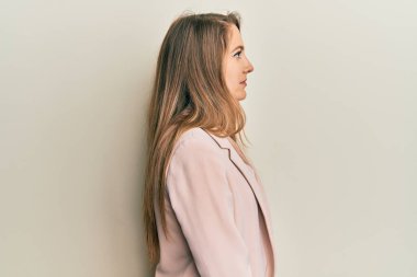 İş ceketi ve gözlük takan genç sarışın kadın, rahat profil pozu veriyor, kendine güvenen bir gülümsemesi var.. 