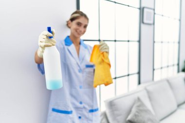 Beyaz kadın temiz üniforma giyiyor. Elinde temiz ürünler var.