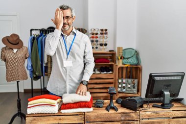 Orta yaşlı İspanyol bir adam perakende mağazasında yönetici olarak çalışıyor. Bir gözünü elinle kapatıyor. Yüzünde kendine güvenen bir gülümseme ve şaşırtıcı bir duygu var.. 