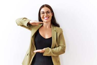 Genç esmer kadın izole edilmiş arka planda duruyor. Ellerinde büyük ve büyük bir işaret, ölçü sembolü var. Kameraya bakıp gülümsüyor. ölçüm kavramı. 