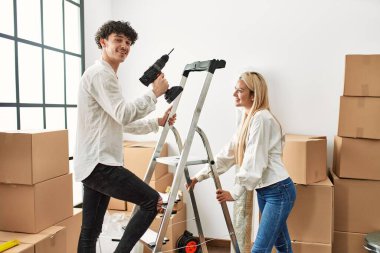 Yeni evinde elinde matkapla merdivenleri çıkan bir adam..