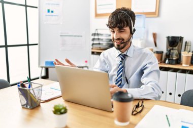 Ofiste çalışırken gülümseyen İspanyol bir çağrı merkezi ajanı..