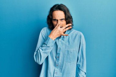 Gündelik kıyafetler giyen genç İspanyol adam pis ve iğrenç bir koku alıyor, dayanılmaz bir koku, nefesini burnunda tutuyor. Kötü kokuyor. 