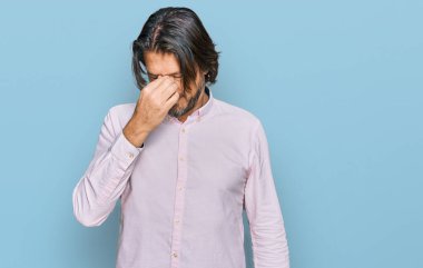 Orta yaşlı, iş gömleği giyen yakışıklı adam yorgun burnu ve gözleri ovuşturup yorgun ve baş ağrısı çekiyor. Stres ve hüsran kavramı. 