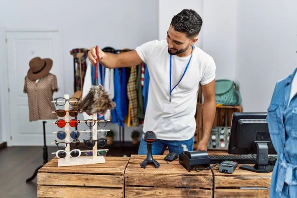 若いアラブ人男性店主クリーニング眼鏡作業で衣料品店 — ストック写真