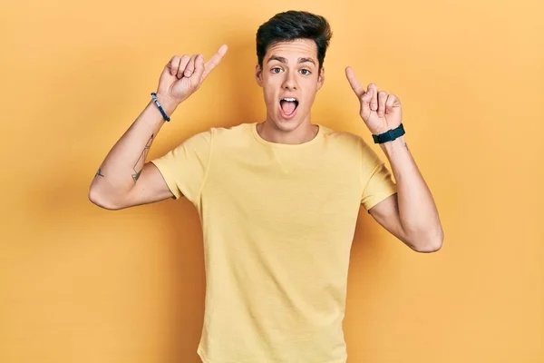 Junger Hispanischer Mann Lässigem Gelben Shirt Lächelt Erstaunt Und Überrascht — Stockfoto