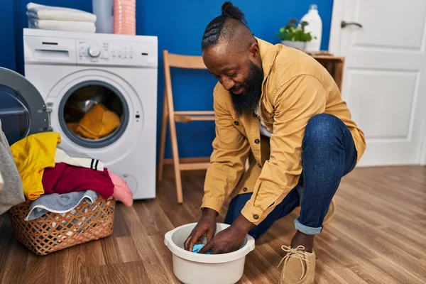 Young African American Man Cleaning Cloth Cube Water Laundry Room — стоковое фото