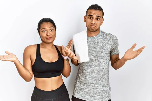 Young Latin Couple Wearing Sportswear Standing Isolated Background Clueless Confused — Stockfoto