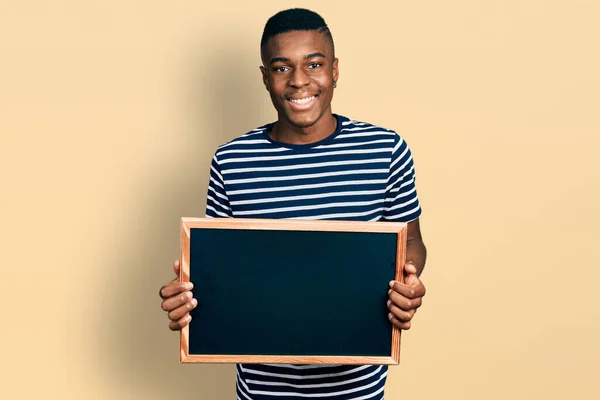 Młody Afrykański Amerykanin Trzymający Tablicę Uśmiechem Twarzy Wykazujące Zęby — Zdjęcie stockowe