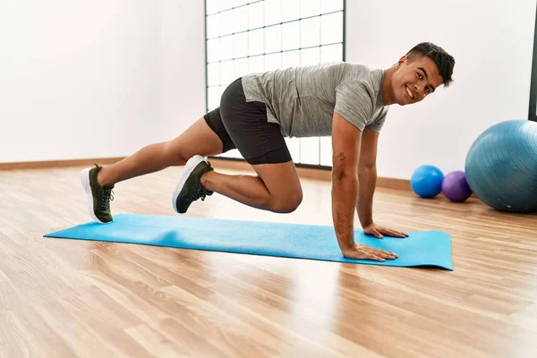 Joven Hispano Sonriendo Confiado Entrenamiento Abs Ejercicio Centro Deportivo —  Fotos de Stock