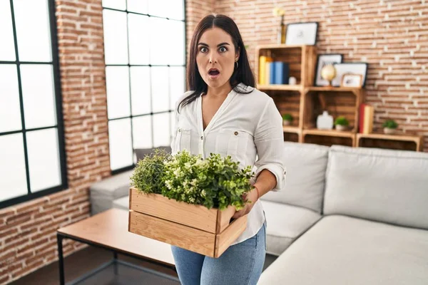 Ung Latinamerikansk Kvinna Håller Gröna Växter Vardagsrummet Rädd Och Chockad — Stockfoto