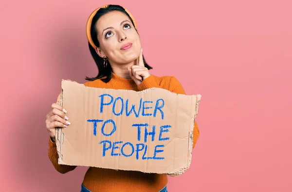 Chica Hispana Joven Sosteniendo Poder Pancarta Gente Cara Seria Pensando —  Fotos de Stock