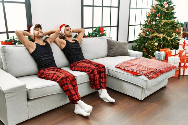 二つのヒスパニック系男性カップルリラックスとともに手上の頭座ってクリスマスツリーにホーム — ストック写真
