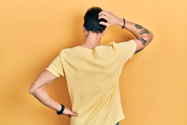 Νεαρός Ισπανός Που Φοράει Κίτρινο Μπλουζάκι Ανάποδα Σκεπτόμενος Την Αμφιβολία — Φωτογραφία Αρχείου