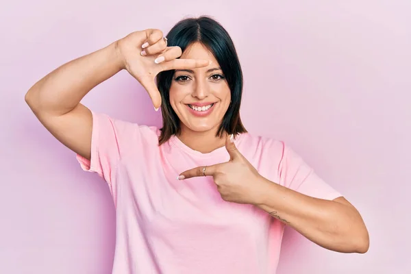 Jovem Hispânica Vestindo Camiseta Rosa Casual Sorrindo Fazendo Moldura Com — Fotografia de Stock